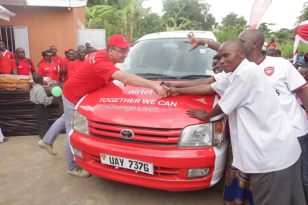 Airtel Uganda MD handing over the car to Mary Kabiito alongside her husband and son.