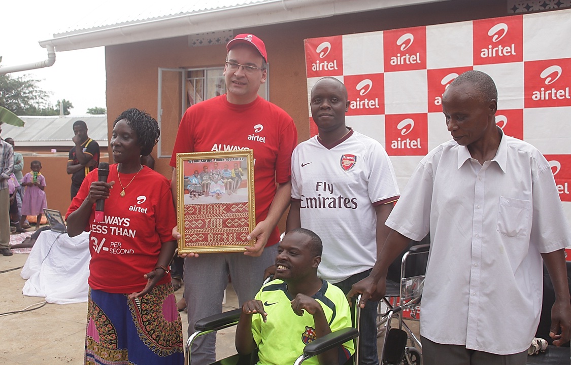 L-R Mary Kabiito, Airtel Uganda MD Tom Gutjahr, Mary's son and her husband Mr. Kabiito handing over a gift to the Airtel MD 2