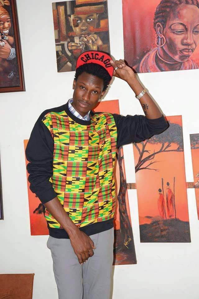 Lubega poses in front of his artworks 
