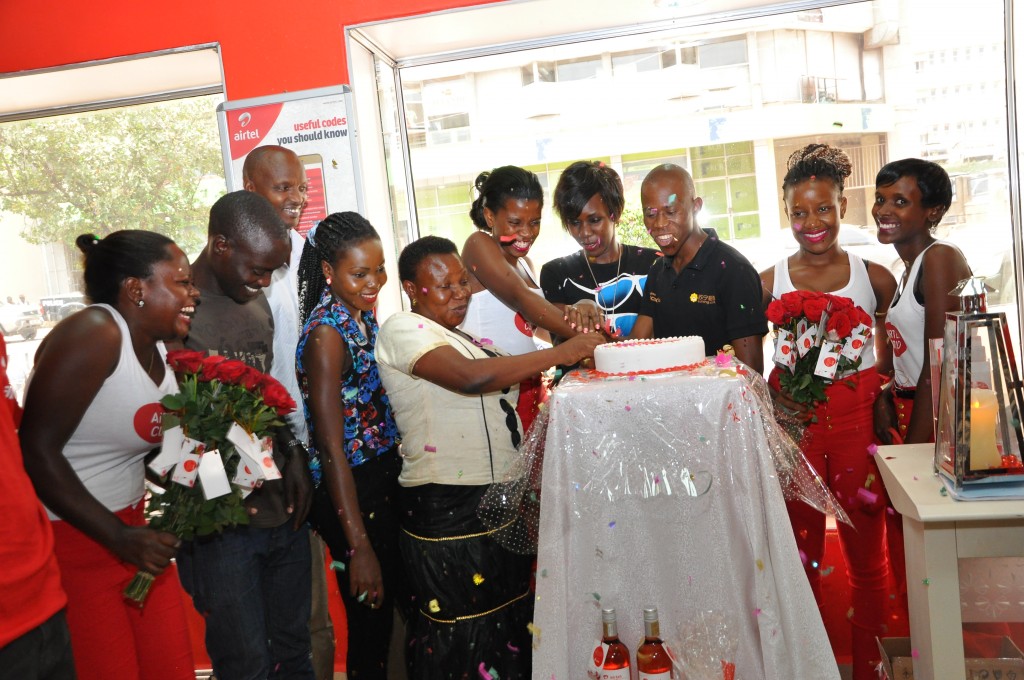 The Airtel staff members and their customers at Jinja Road Airtel shop, cut the cake during the Pre-valentines celebration.