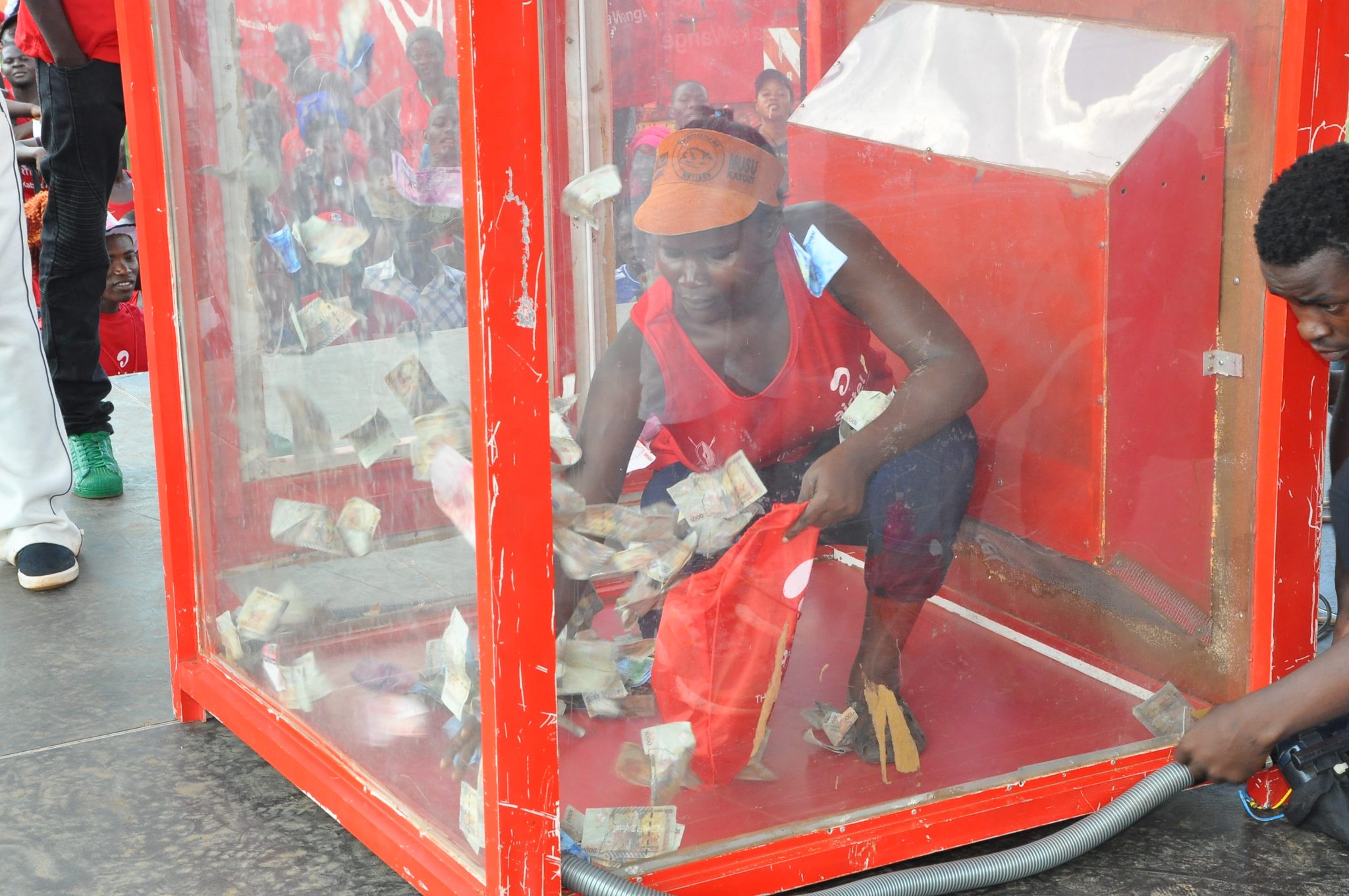 Farida Nasegge collects money from the Airtel money Booth during the yoola Amajja activation at the Kabaka Run.