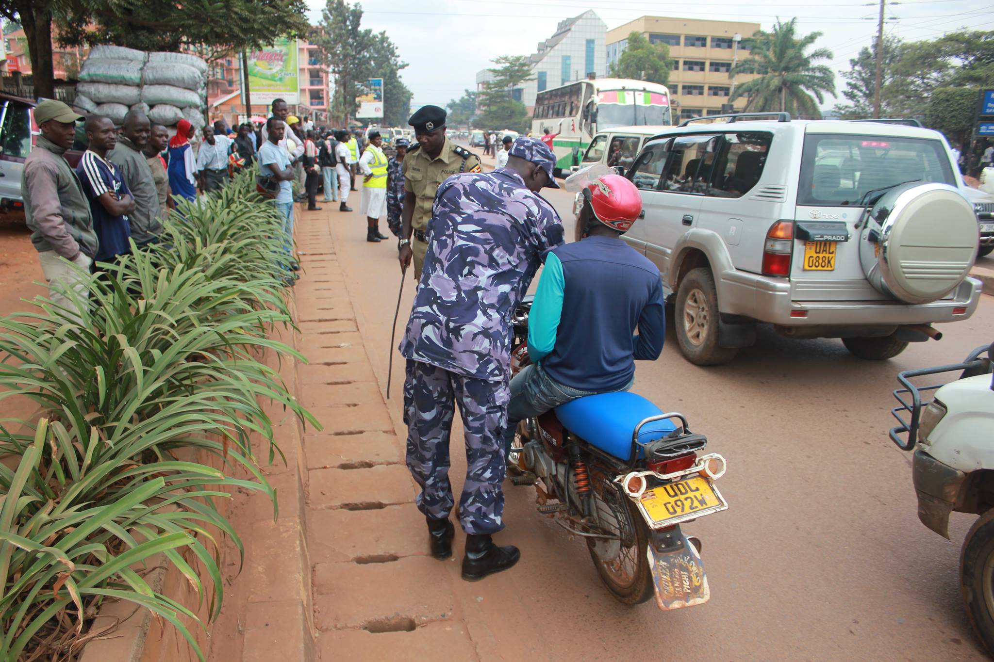 A police officer in the process of confiscating a boda while revellers look on.