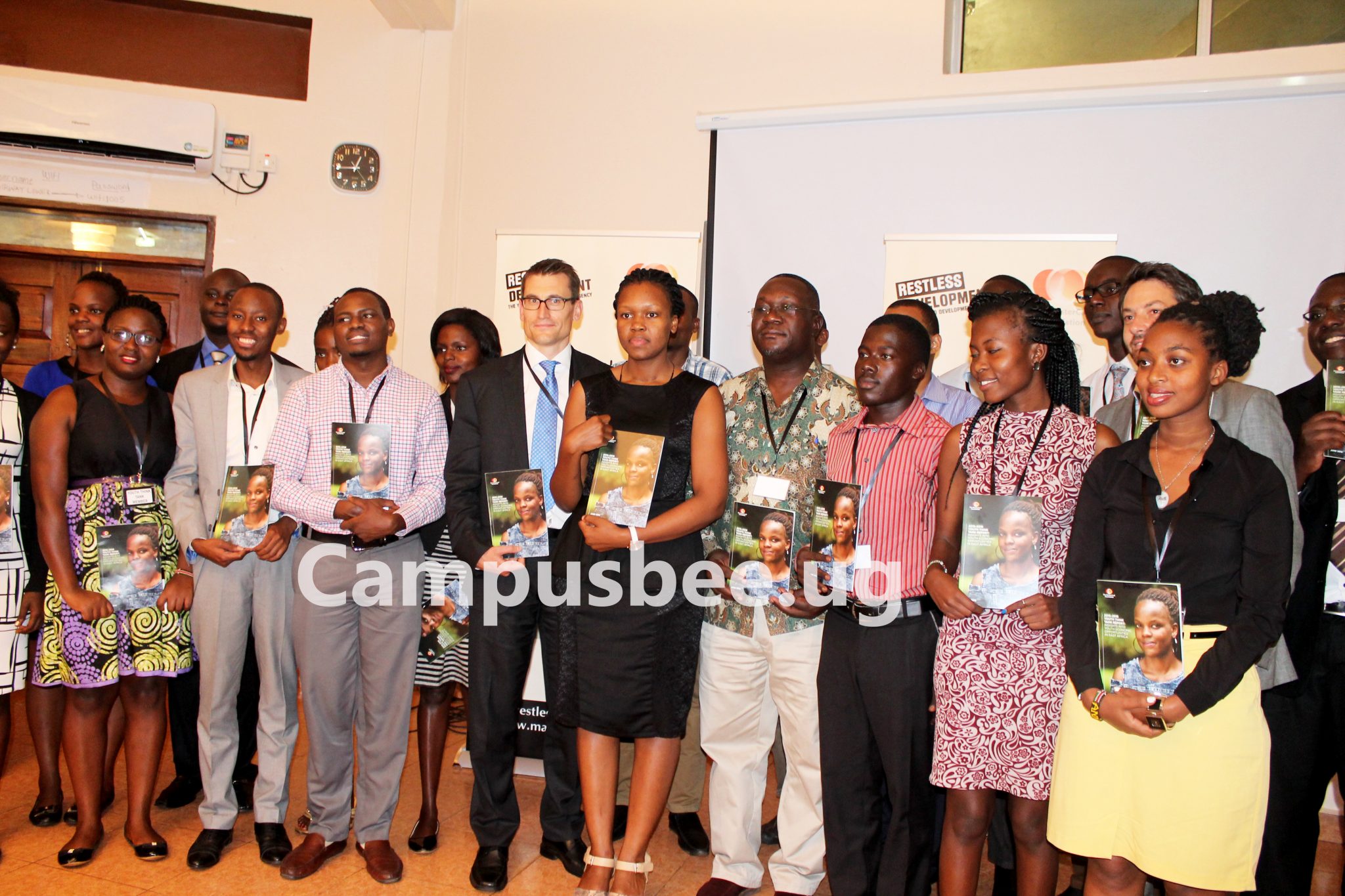 A group photo involving the Restless Development and MasterCard foundation members holding the Youth Think Tank Report