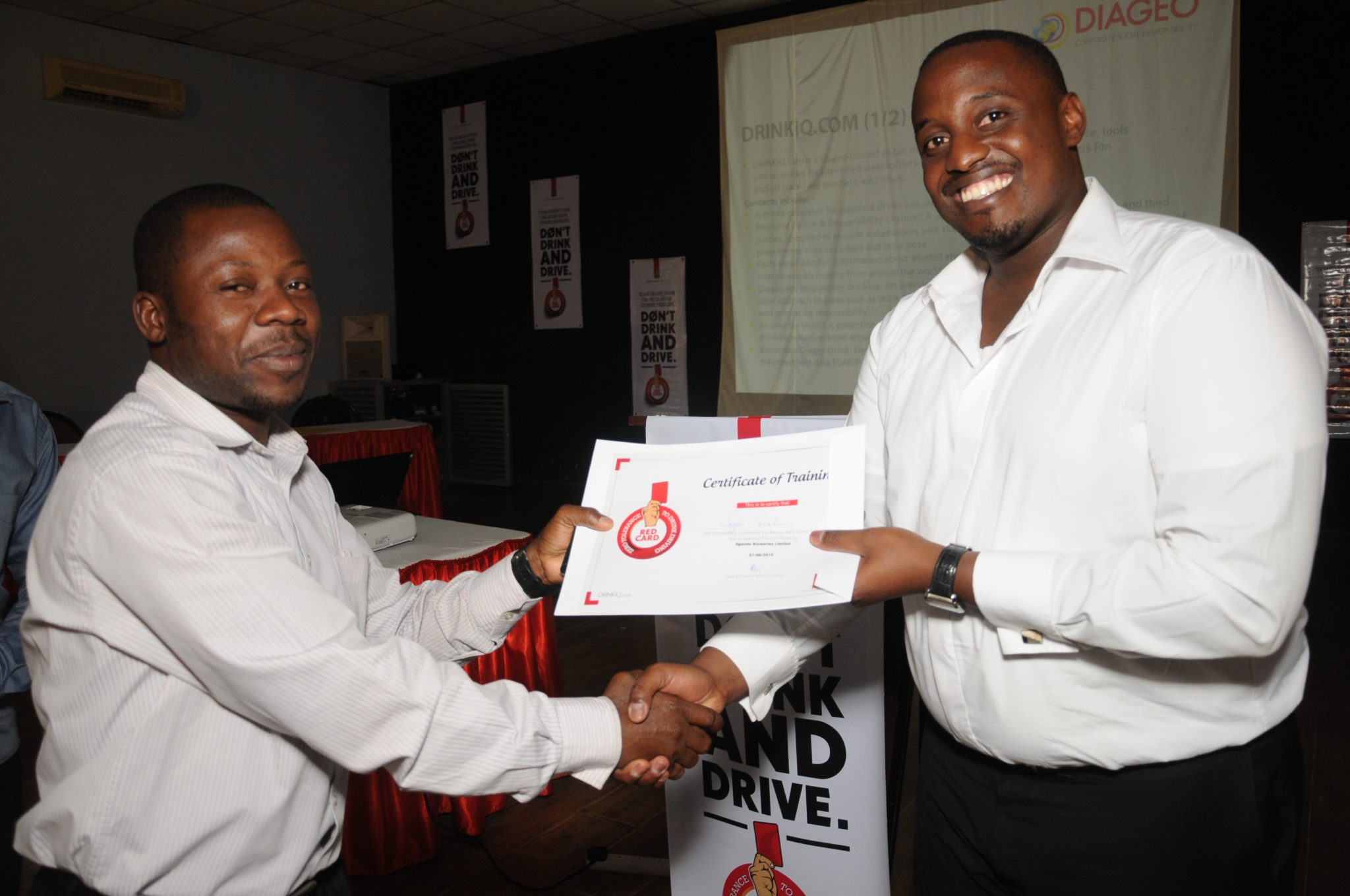 Ronald Tumwizere, UBL’s Promotion Manager handing over a certificate to one of the bar tenders who completed the responsible serve training