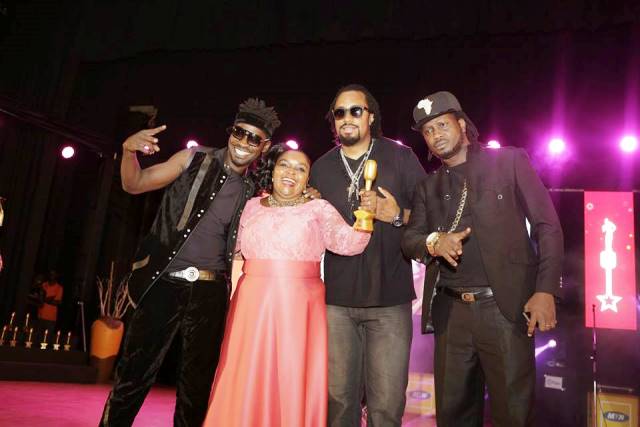 Joanita Kawalya poses with Navio, Bebe Cool and Bobi Wine after winning the lifetime achievement award