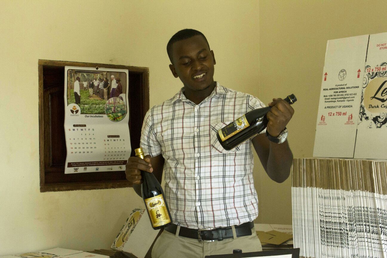 Finance Manager, Breach Niwagira displays their well packaged coffee wine bottles 