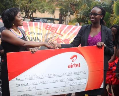 KCCA Executive Director Ms. Jennifer Musisi receives a cheque worth UGX100m from Airtel's Brand Assets and Properties Manager Noela Byuma
