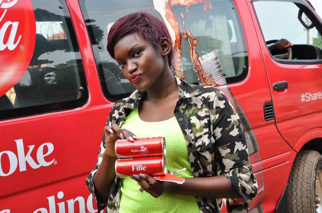 Fille poses with his personalized branded Coca-Cola cans bearing her name.