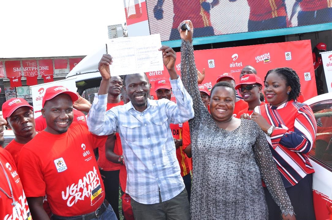 Ritah the 4th lucky winner of the MujjeTulumbe promotion shows off the key and log book to hert new toyota premio from Airtel Uganda
