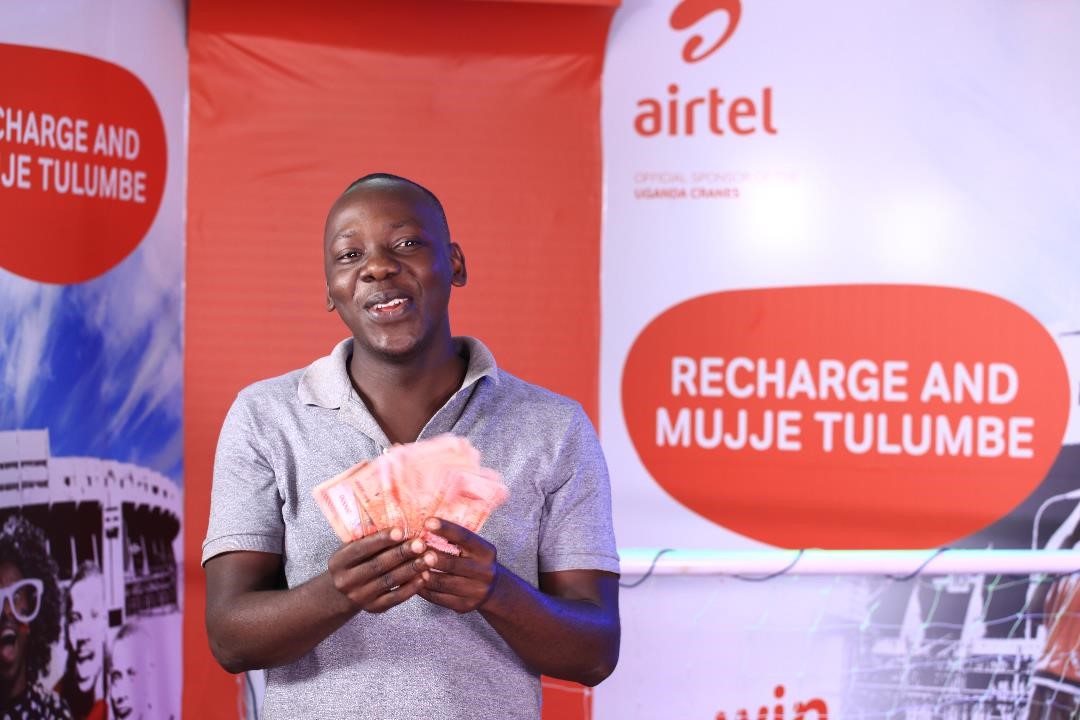Sembatya Vincent, Fruit Vendor from Wakiso pose for a photo with his UGX 1,000,000 he won in the Recharge Promotion