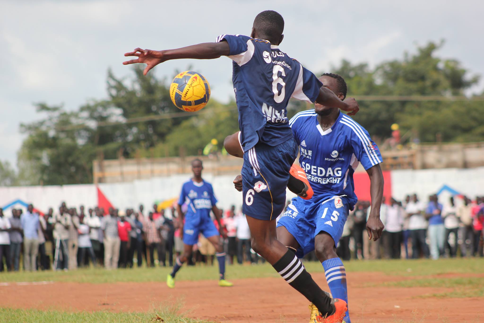 Obalim Brian Isaac jumps over a player from Nkumba to win over the ball