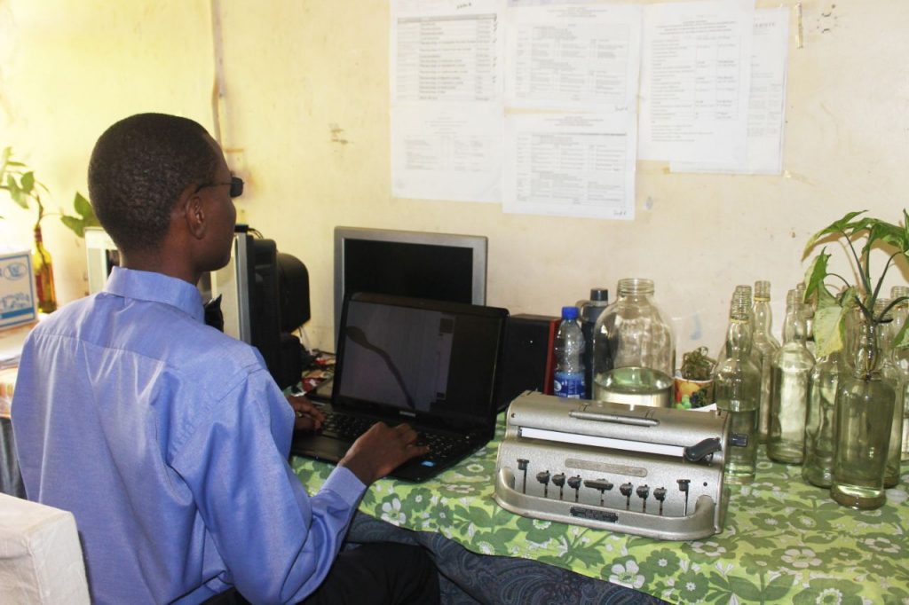 Alex Lukwago on his computer