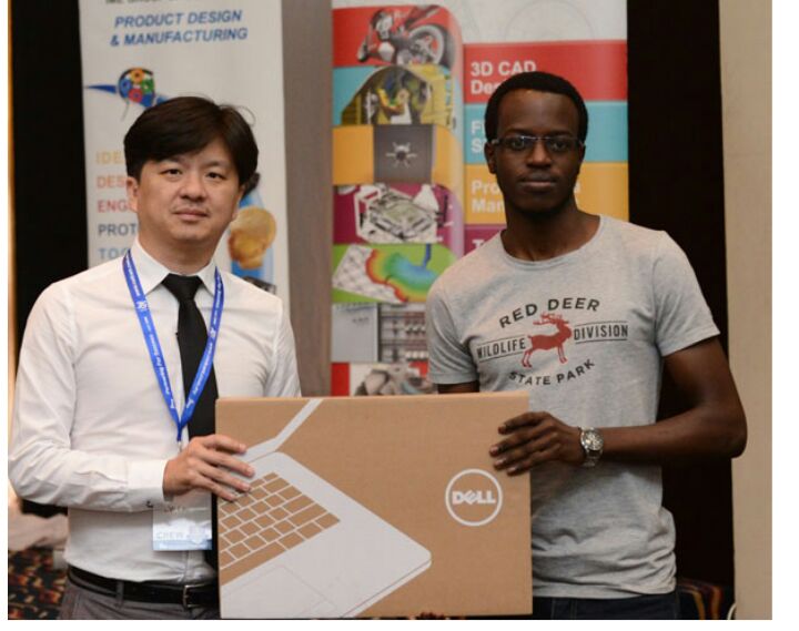 Yusuf receiving his laptop from IME Technology Sales director,  Lau Chee Wei