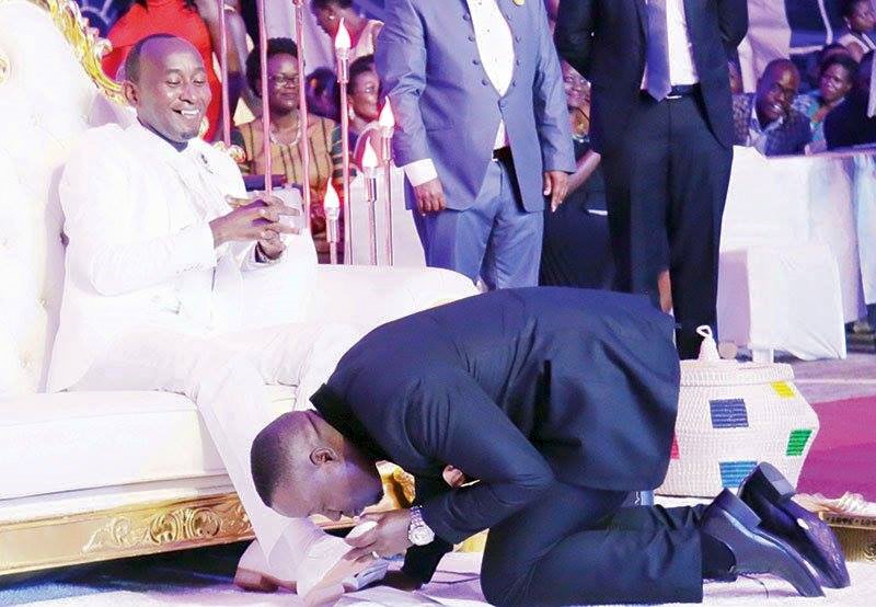 Joseph Kabuleeta kissing Mbonye's feet