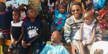 Joshua Rukundo (in shades) with the children benefiting from their charity