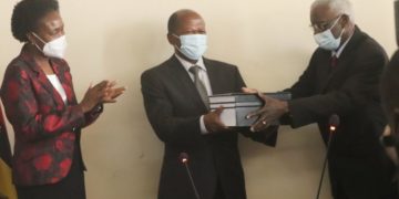 (C-R) Minister Muyingo receiving (on behalf of government) the Memorandum of Agreement from Mr. Tom Butime (Representative of the proprietors and management of the University)