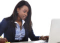 young attractive and efficient black ethnicity woman sitting at office computer laptop desk typing concentrated isolated on white background in business career and success concept