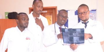 Dr. Mwesigwa and the residents examining an x-ray scan of one patients in the urology unit