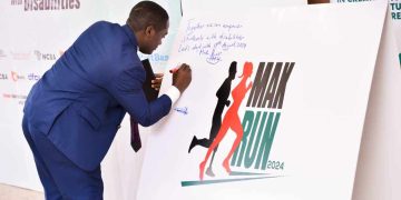 Mak Guild president Vincent Nsamba Lubega signs against Mak Run 2024 placard